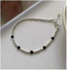 Détail du bracelet en perles d'argent S925 avec agate noire et breloque en cœur