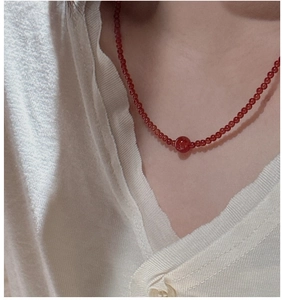Detailed view of S925 sterling silver red agate beaded necklace on a model's neck