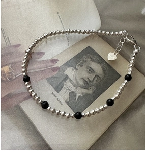 Macro d'un bracelet en argent S925 avec perles d'onyx noir et fermoir à breloque cœur
