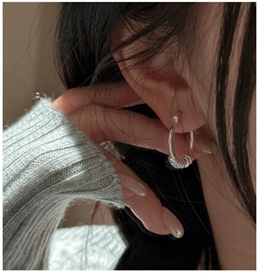 Gros plan de boucles d'oreilles créoles en argent S925 avec texture torsadée sur un mannequin