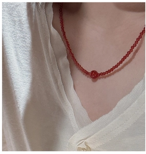 Macro shot of S925 silver necklace with red agate beads and a central large accent bead