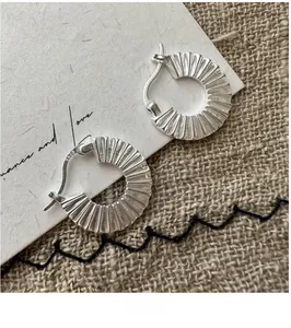 Macro shot of S925 sterling silver pleated hoop earrings with delicate folded texture