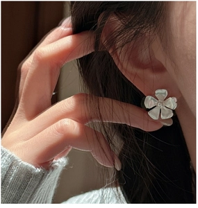 Macro view of matte S925 silver flower stud earring on ear with frosted finish details