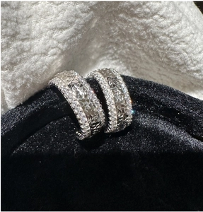 Détail macro de boucles d'oreilles S925 avec texture cœur et pavé de zircons fins