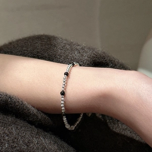 Bracelet minimaliste en argent S925 avec perles d'agate noire sur le poignet d'une femme