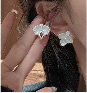 Detail of S925 silver orchid stud earring with brushed texture and red zircon gem
