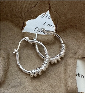 Vue macro détaillée des créoles nœud en argent S925 avec design spirale texturé élégant