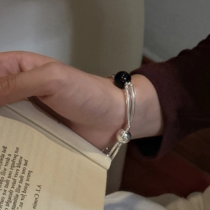 Minimalist S925 sterling silver layered bracelet with black onyx bead on a female wrist