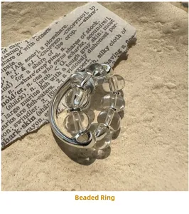 Macro shot of minimalist S925 silver beaded ring with clear crystal on vintage background