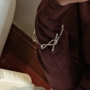S925 sterling silver knotted bracelet with OT buckle on a deep red knit background