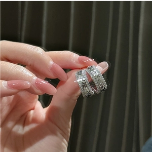 Détail de créoles en argent S925 avec zircons pavés et sculpture latérale ajourée