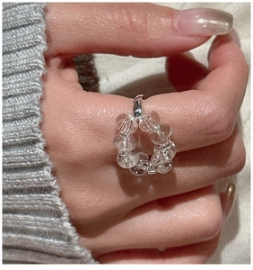 Detailed shot of S925 silver beaded ring with white crystals on a knitted sleeve background