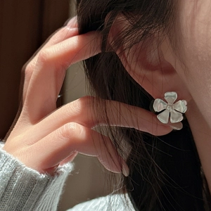 Minimalist S925 sterling silver floral earrings with matte finish worn by model