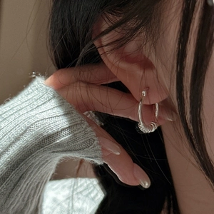 Boucles d'oreilles créoles nouées en argent S925 avec texture en spirale sur modèle