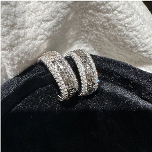 Vue détaillée des créoles en argent S925 avec motifs cœurs embossés et micro-pavé de zircons