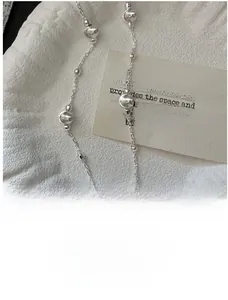 Macro detail of S925 sterling silver beaded necklace with polished cat-eye effect beads