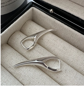Dettaglio macro di orecchini a cerchio in argento S925 con design a corno lucido