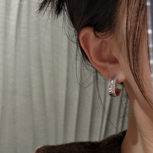 Boucles d'oreilles créoles C en argent S925 avec texture glace pilée sur modèle