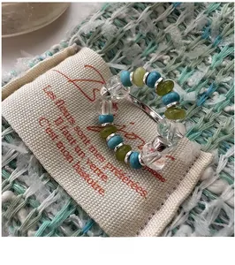 Detail shot of vintage beaded ring with turquoise and clear beads on canvas bag