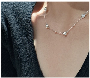 Detail of S925 sterling silver beaded necklace showing irregular metal spheres on a fine chain