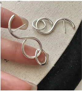 Nahaufnahme der S925 Sterlingsilber Creolen mit abstraktem Spiraldesign in Silber
