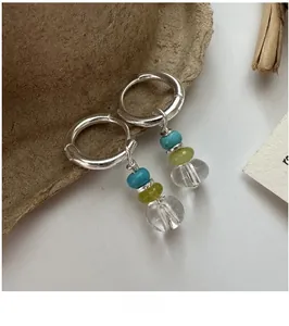 Close-up of S925 silver hoop earrings with blue, green, and clear crystal beads