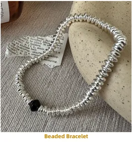 Detail of vintage S925 silver beaded abacus bracelet with black accent on textured fabric