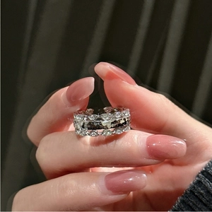 Macro shot of silver S925 ring featuring hollow geometric patterns and zircon stones