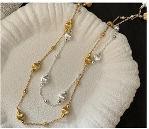 Detail showing two-tone gold and silver beaded S925 sterling silver chain on a tray