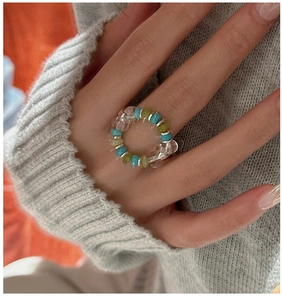 Close-up of S925 silver beaded elastic ring with turquoise and green beads on finger