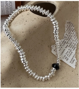 Macro detail of silver abacus beads bracelet with black bead on ceramic decor