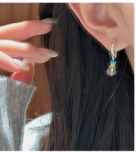 Close-up of S925 silver beaded hoop earrings with clear and colorful crystals on model