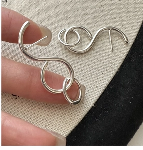Nahaufnahme minimalistischer S925 Sterling Silber Creolen mit abstraktem Kurvendesign