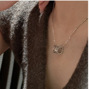 Gros plan d'un pendentif cylindrique en argent sur une chaîne à billes pour femme