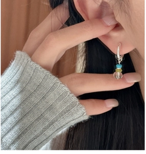 Close-up of S925 silver hoop earring with blue, yellow and clear crystal beads on model