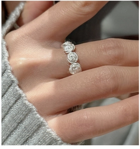 Close-up of S925 sterling silver vintage rose flower ring on hand with a soft knit sweater