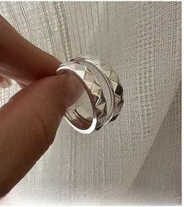 Détail des boucles d'oreilles créoles en argent S925 avec texture gravée CNC géométrique