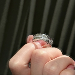 Detailed close-up of wide silver band ring featuring multiple rows of micro-pave zircons