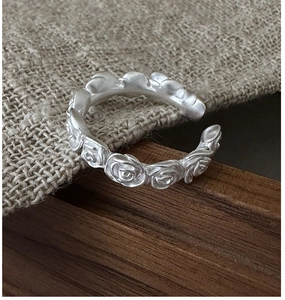 Close-up of matte silver vintage rose floral relief on an adjustable open ring