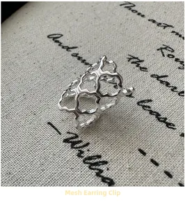 Detail of silver hollow mesh ear cuff with modern geometric interlocking structure