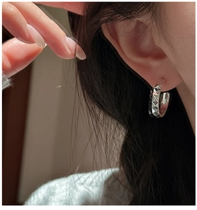 Gros plan de créoles en argent sterling S925 avec texture de rivets pyramidaux en 3D