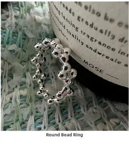 Close-up of a minimalist 925 silver beaded ring on a soft knitted background