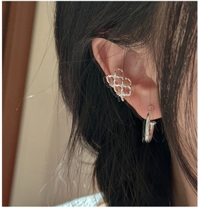 Detail of S925 silver geometric ear cuff and nail design earring worn by a model