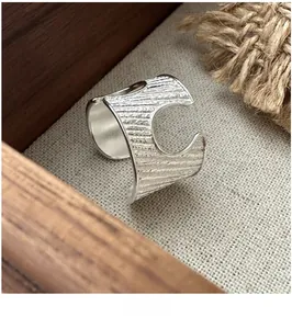 Close-up of S925 sterling silver open ring featuring irregular textured wood grain pattern