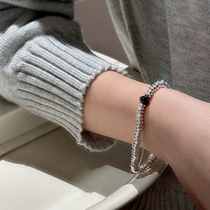 S925 sterling silver beaded bracelet with black heart charm worn on female wrist