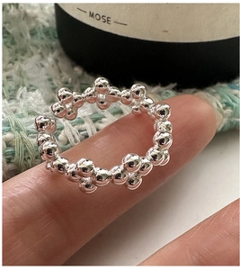 Detail of S925 sterling silver beaded ring featuring a stacked 3D texture on finger