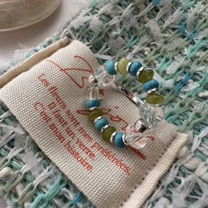Bohemian beaded ring with turquoise and silver accents on a minimalist canvas bag background