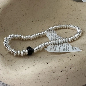 S925 sterling silver beaded abacus bracelet with black bead on ceramic plate