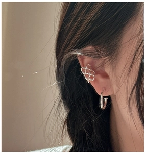 Close-up of S925 sterling silver geometric ear cuff and stud set on female ear