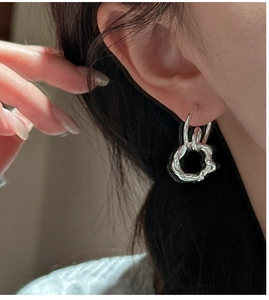Detailed close-up of S925 sterling silver earrings with a twisted double-hoop design